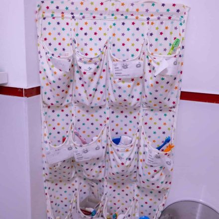 Grup sanitar dotat cu: dezinfectant, dispensere, consumabile, suporturi din panza cu buzunare pentru materialele copiilor